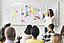 Woman points to a board with man documents in front of a group