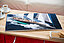 Offenes Fotoalbum auf Holztisch mit einem Bild von einem Segelboot