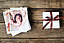 Pile of printed photos and a gift box next to it